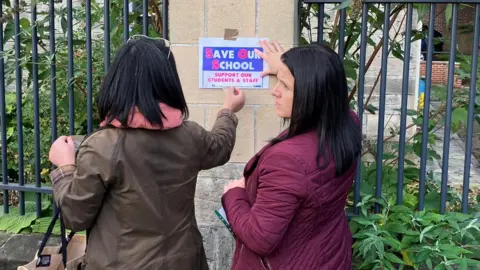 Parents outside St Leonard's Catholic School putting up posters protesting Raac