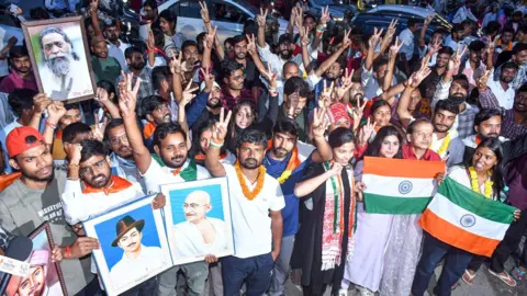 ANI Group of people posing for the camera, holding Indian flags and posters