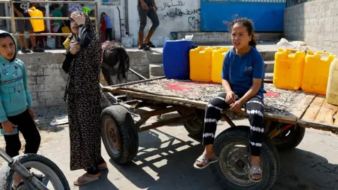 IBRAHEEM ABU MUSTAFA children with water barrels