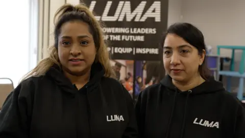 Dawid Wojtowicz/BBC Ayesha and Ranjna, both of whom are wearing black hoodies