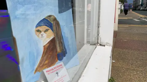A version of the Girl With the Pearl Earring, with a cat's face - in a shop window.