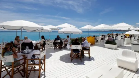 Reuters Customers enjoy a lunch on the terrace of a beach restaurant in Nice, France