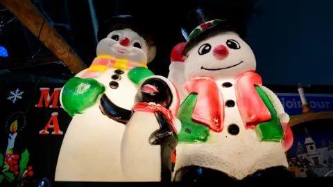 Two large, plastic, light up snowmen on Lisa Watts' stall.