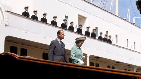 PA Media Queen Elizabeth II and the Duke of Edinburgh disembarking from the Royal Yacht Britannia in Portsmouth Dockyard in 1977