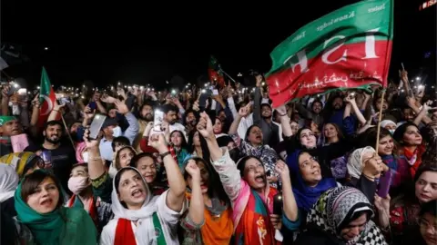 Reuters Supporters of the Pakistan Tehreek-e-Insaf (PTI) political party light up their mobile phones and chant slogans in support of Pakistani Prime Minister Imran Khan during a rally in Islamabad, Pakistan. Photo: 4 April 2022