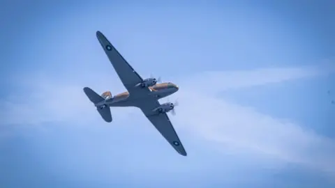Nadine Hudson-Featherstone A 1942 Dakota aircraft in the blue sky