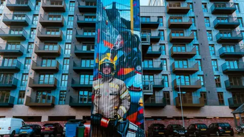 Julian Preece Photography A giant mural painted on the side of the Avon Fire and Rescue building in Bristol showing a firefighter and a call handler