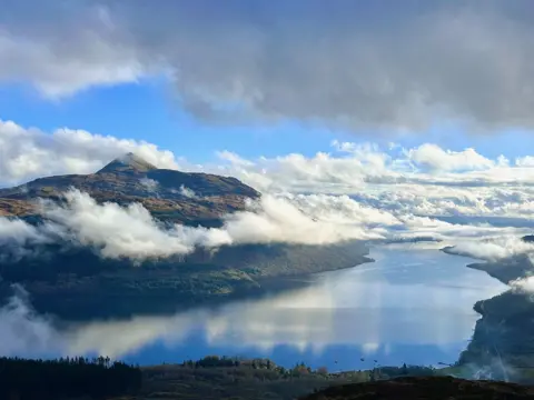 Charlie McGinn A view looking across Loch Lomond to the mountain Ben Lomond, with clouds and blue sky