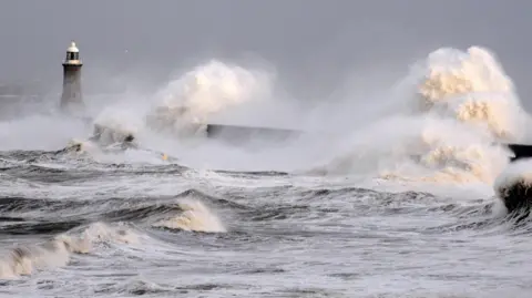 Large waves crashing against Tynemouth piers at Tynemouth beach.