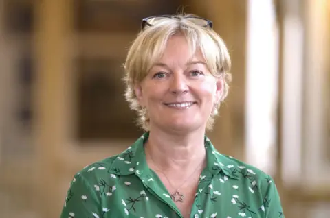 PA Media Jo Malone wearing green patterned dress and necklace with a star pendant 