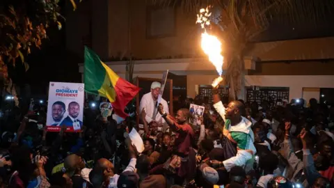 EPA Supporters of opposition politician Ousmane Sonko celebrate his release outside his home in Dakar, Senegal, 15 March 2024.