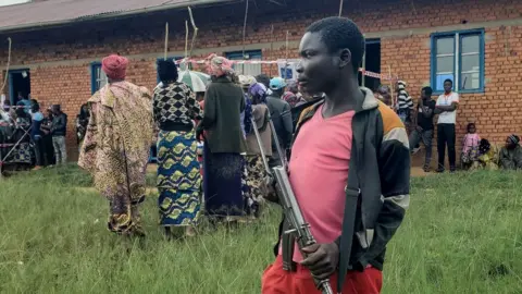 AFP A Patriots Union for the Liberation of Congo (UPLC) militiaman stands guard at a polling station in Kalunguta, Beni Territory, North-Kivu Province, Eastern Democratic Republic of Congo, on December 20, 2023.