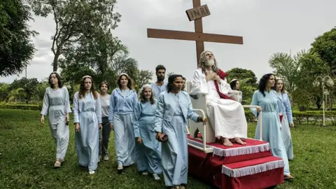 INRI Cristo is wheeled around their compound on a rolling pedestal.