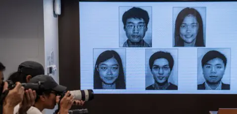 Pictures of activists wanted by Hong Kong officials on screen at a police press conference in July 2023