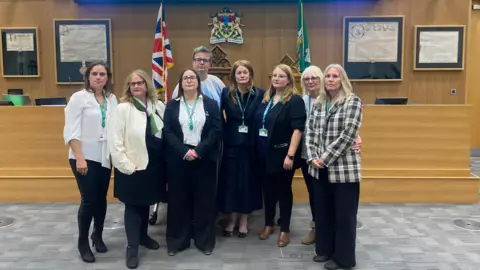 Christopher Day/LDRS The eight female Liberal Democrat councillors who resigned the party whip stand in a council chamber.