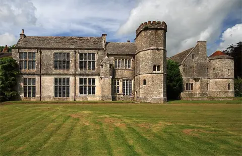 Mike Searle The south side of Wolfeton House near Dorchester, a medieval and Elizabethan mansion with tall lead paned windows, a pitched roof and a crenelated tower at one end.