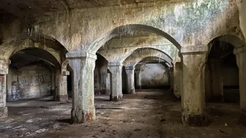 A Victorian undercroft beneath the Forth Goods Yard in Newcastle. The underground space is made of several archways with graffiti on some of the walls.