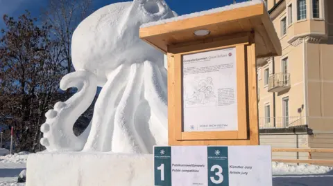Lily Marsh/Steve Roche A snow octopus with a sign in front the says Great Britain and underneath there is a sign that reads. 1, public competition and 3, artists jury