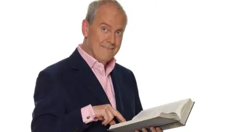 Jim Marks/BBC Gyles Brandreth holding book