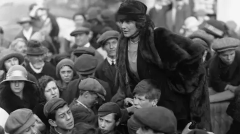 Corbis via Getty Images Nancy Astor (1879-1964) amongst a group of children during the 1923 election campaign in her constituency of Plymouth. She succeeded her husband in the seat in 1919, and was the first woman to sit in the House of Commons.
