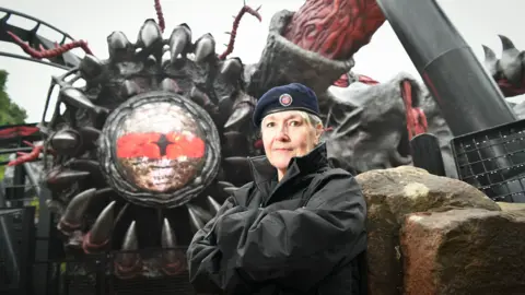 PA woman standing in front of rollercoaster ride