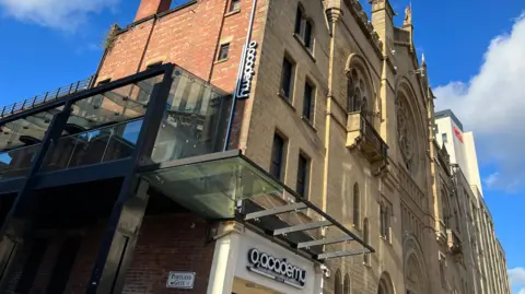 The O2 Academy in Leeds, pictured from outside the building, which has a yellow and orange-brick exterior.