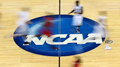 Men's basketball players on a court that says NCAA