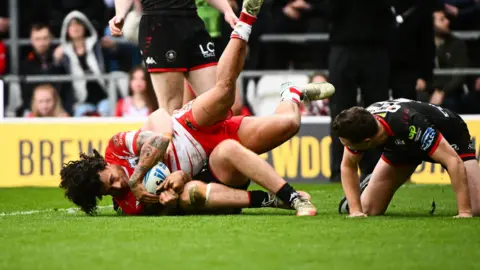 Tristan Sailor scores for St Helens late on against Wigan Warriors