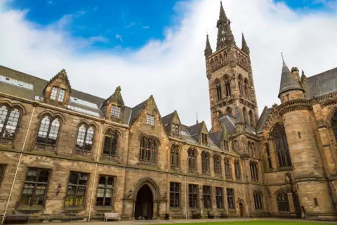 Getty Images Glasgow University's gothic style main building which surrounds an inner courtyard. The tower reaches up to a tall height with turrets