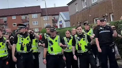 Officers in hi-vis gear standing on a street in Glasgow.