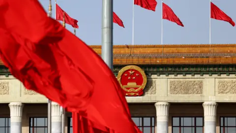 Getti Chinese flags in front of a government building.  