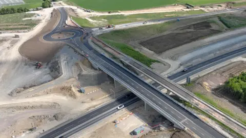 An image of a newly built road in Roxton, Bedfordshire, showing a new bridge, an old bridge, a road underneath, a roundabout and another new road. 
