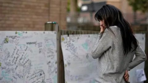 Reuters A woman reacts in front of a message wall near the scene of the fire that destroyed the Grenfell Tower block