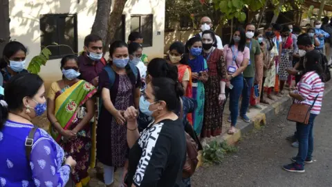 Getty Images Health workers queue to receive a dose of a Covid-19 coronavirus vaccine at the Cooper hospital in Mumbai on January 16, 2021.