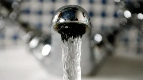 Water flows out of a metal tap