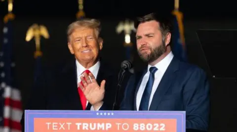 Getty Images Trump and Vance stand side by side behind the podium