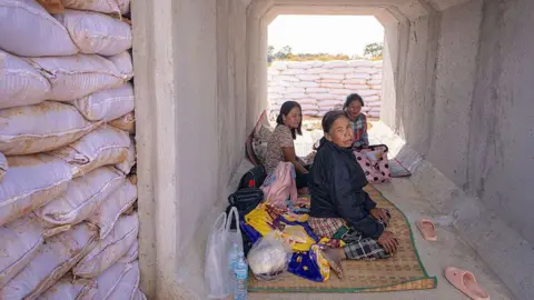 AFP via Getty Images Residents take shelter in a bunker following clashes along the Thai-Cambodia border in Thailand's Sa Kaeo Province on December 9, 2025
