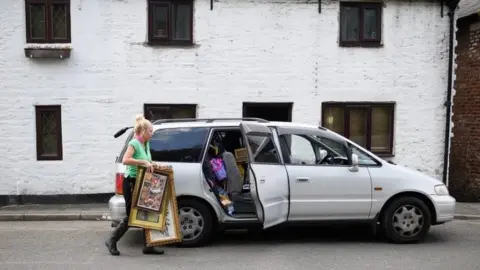 Getty Images Woman packs paintings into car