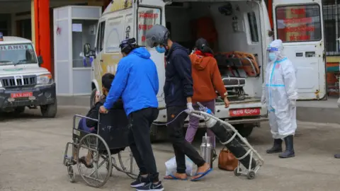 Getty Images A man infected with Covid-19 arrives at hospital in Kathmandu