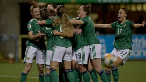 Getty Images NI women's football team celebrate after scoring a goal