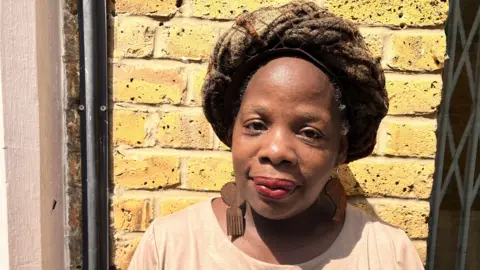 Ngozi Fulani in a creamT-shirt, and looking at the camera.