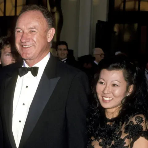 Getty Images Gene Hackman dan Betsy Arakawa di Oscar 1989, tersenyum dalam gaun malam