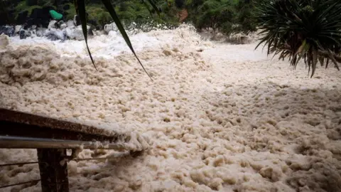 Getty Images Sea foam is pushed by record-breaking waves caused by the outer fringe of Cyclone Alfred at Point Danger in Coolangatta