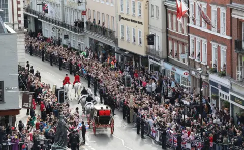 PA Crowds cheer Jack Brooksbank and Princess Eugenie as they embark on a carriage ride following their wedding at Windsor Castle