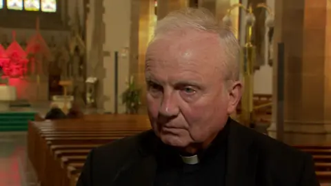 Bishop Donal McKeown standing in a church. 