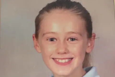 Rhiannon Evans Rhiannon Evans in her school days smiles at the camera 
