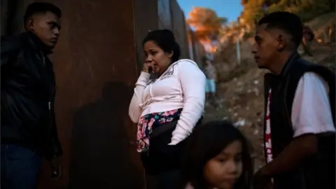 Reuters Migrants from Honduras stand by the border fence in Tijuana, Mexico on 2 December, 2018