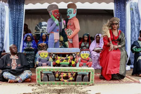 DANIEL BELOUMOU OLOMO/AFP Members of the royal family and a guardian of the throne surround the throne of Mouhammad-Nabil Mfonrifoum Mbombo Njoya (unseen), Sultan King of the Bamouns, ahead of the inauguration ceremony of the new Bamoun Kings Museum in Foumban.