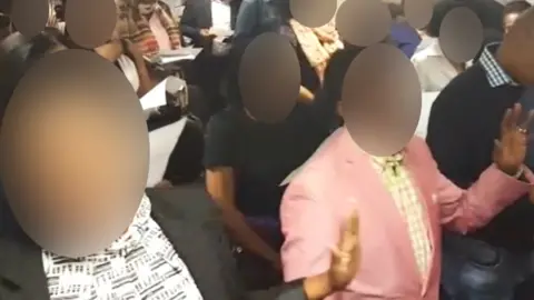 YouTube A screengrab of people at the Rwanda's High Commission in London pledging an oath of loyalty to the RPF