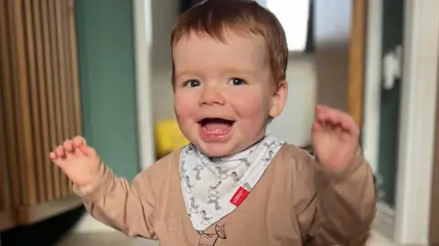 Two-year-old Flynn Fairhurst smiling with his hands up